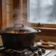 Cast iron pot with steam rising on a gas stove in a warm Australian home kitchen in winter, a wooden spoon resting beside it