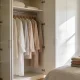 An open wardrobe with neatly hung clothes and folded basics in a bright Australian bedroom