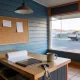 A small shop counter in an Australian suburban main street seen from the customer's side in early morning light, with a plain tablet and a roll of blank paper beside a mug and keys on the counter, blank notes pinned on the wall behind and a quiet street with a parked ute beyond the window