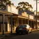 quiet Australian regional town main street with verandah shopfronts, eucalyptus trees and low hills in golden late-afternoon light